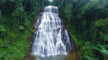 The grand Detian Waterfall cascading down in an impressive series of falls, with water splashing into the pool below surrounded by dense jungle.
