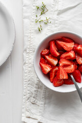 Strawberries, in a bowl, on a white wooden table. .