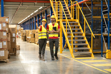 Two colleagues walk through a warehouse smiling, emphasizing camaraderie and support in a logistics and supply chain environment.