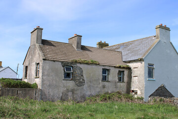 Abandoned old stone home with a tiled roof and exposed brick in Miltown Malbay, County Clare, Ireland