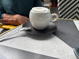 tasse de café capuccino à une terrasse avec une jolie mousse. Tasse ronde et originale