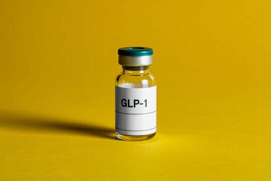 Single clear glass vial of GLP-1 medication with white label on vibrant yellow background, clinical pharmaceutical concept

