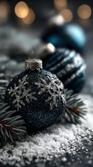 Festive blue glitter ornaments with silver snowflakes on a winter scene with pine branches and snowflakes