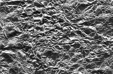 Crumpled aluminum foil texture as silver abstract background