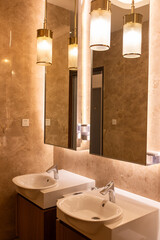 A corner of a public toilet decorated with beige marble