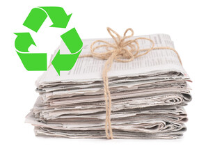 Recycling symbol and stack of tied newspapers on white background. Eco-friendly lifestyle, reusing