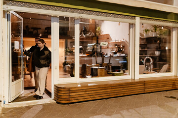 A female owner and a male employee leave the cafe and go outside