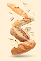 Different types of bread and spikes falling on beige background