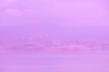 View of the river and mountains in the distance. Light fog. Purple background.