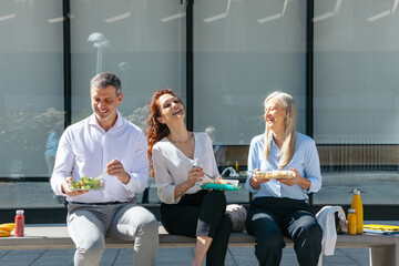 Business people enjoying healthy lunch break together outdoors