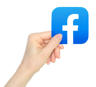Hand holds paper Facebook mobile app icon, on transparent background. Facebook is a social media and social networking service owned by the American technology conglomerate Meta