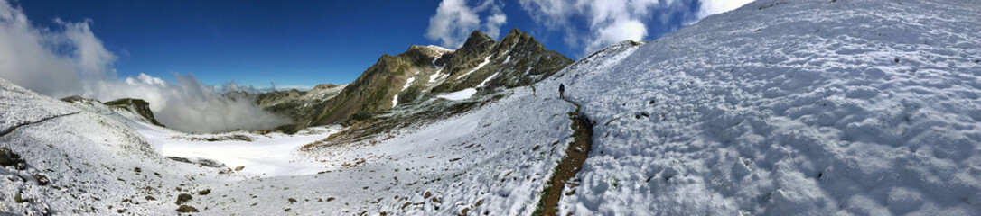 Snowy mountain panorama with cloudy sky and scenic views of rugged peaks