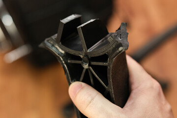 holding broken leg of office chair: workplace trouble, defective chair.