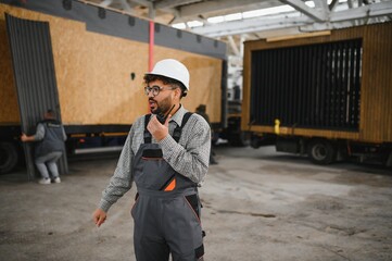 Arab construction worker communicating with walkie talkie in modular house production
