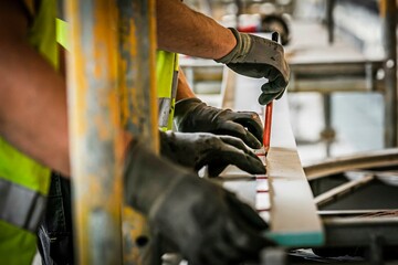 Bauarbeiter zeichnen mit einem Bleistift auf einer Gipsplatte an