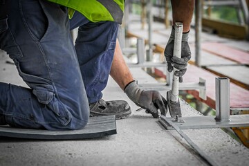 Bauarbeiter befestigt ein Gerüst mit einem Hammer
