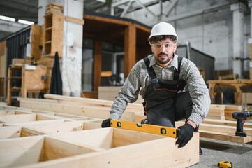 Arab carpenter checking wooden frame with spirit level in workshop