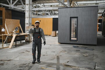 Fototapeta premium Arab construction worker walking in modular house production workshop