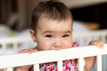 Pain from the eruption of the baby's first tooth. Baby chewing on the crib with his gums to relieve discomfort.