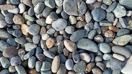 Stones on sea shore, smooth pebbles, marine texture, natural background, coastal scene, seaside detail, beach stones, ocean atmosphere, summer vacation, nature close-up.