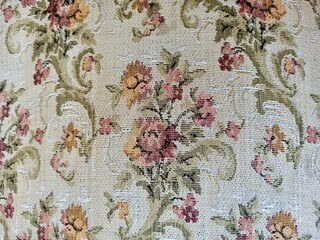 Embroidered floral pattern on tapestry, fabric background, textile texture, needlework detail, vintage style, ornamental design, decorative fabric, woven art, handcrafted pattern, traditional craft. 