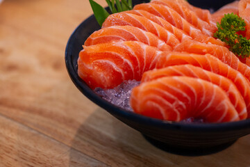 High angle view of salmon seafood in black bowl on table