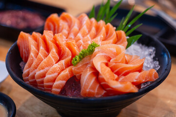 High angle view of salmon seafood in black bowl on table