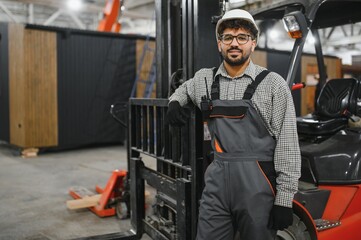 Arab forklift operator leaning on machine in modular house factory © Serhii