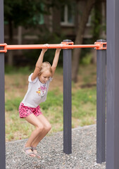 Fototapeta premium little european girl 7 years old having fun on the sports ground