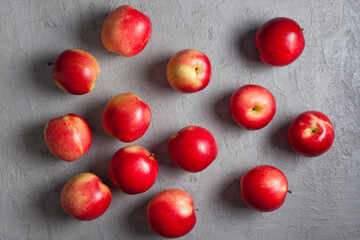Scattered Red Apples on Light Gray Concrete Background