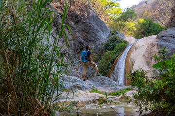 Hiker admiring the la magdalena waterfalls in tlatlauquitepec, puebla, mexico