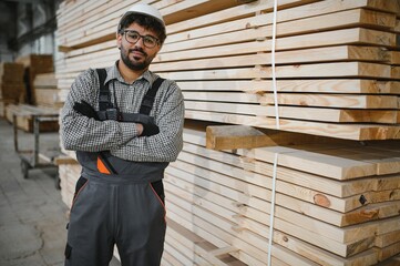 Arab carpenter posing with arms crossed in lumber warehouse
