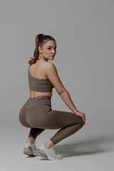 Fitness enthusiast performing a squat in stylish activewear during a studio session