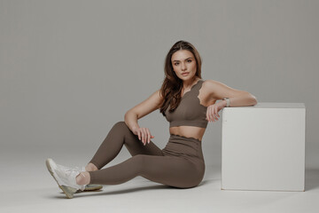 Model poses in stylish activewear against a neutral background showcasing fitness and fashion
