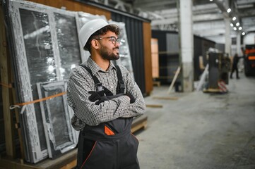 Arab construction worker smiling in modular house production workshop