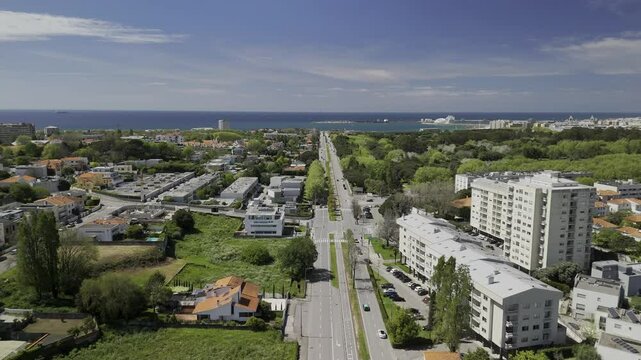 Drone flies northwest along Avenida da Boavista through the Beco das Carreiras neighborhood on sunny day in Porto, Portugal