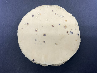 Raw, thin, crispy papad made from lentil flour and seasoned with black pepper. Indian snacks black background 