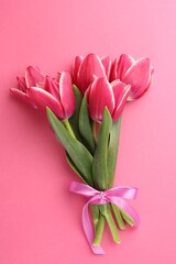 Fototapeta premium Bouquet of beautiful tulips on pink background, top view