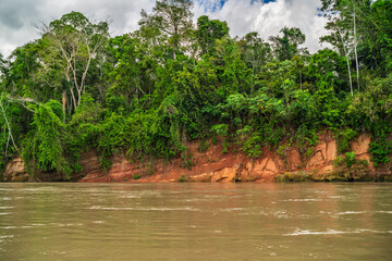 Heavy rain over the Amazon River and forest, with a small boat navigating the water amidst the storm