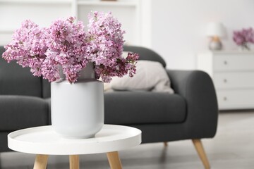 Beautiful lilac flowers in vase on table indoors, space for text