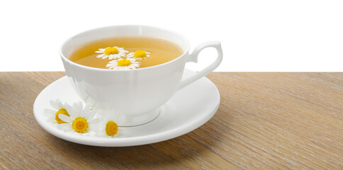 Delicious chamomile tea in cup and fresh flowers on wooden table against white background