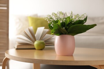 Bouquet of beautiful lily-of-the-valley on coffee table indoors