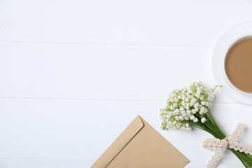 Bouquet of beautiful lily-of-the-valley flowers, coffee and envelope on white wooden background, flat lay. Space for text