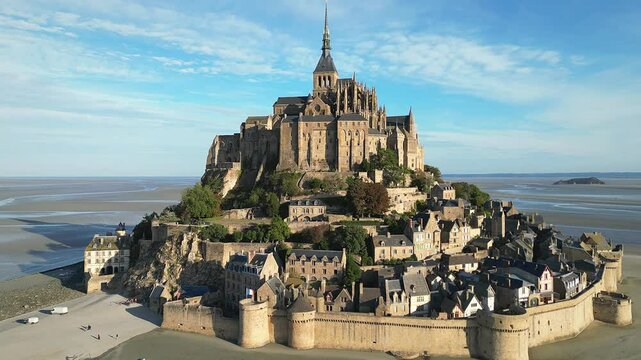 Drone view of Mont-Saint-Michel Abbey nestled in expansive tidal landscape with rural land in France