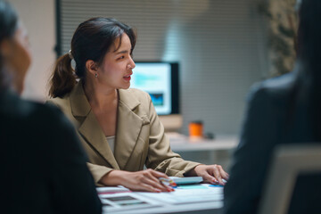 Young businesswoman leading a meeting with her colleagues, discussing financial reports and strategies in a modern office