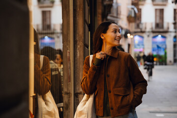 Obraz premium Woman smiling and looking away, on the street