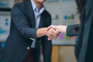 Two business professionals engaging in a handshake, celebrating the successful closing of a deal in...