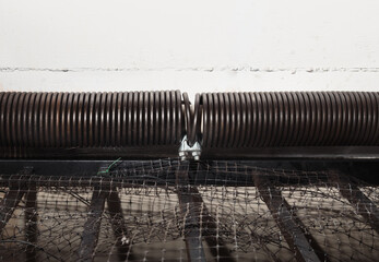 Clamped garage door spring or torsion spring on overhead sectional door. Close up of temporary...