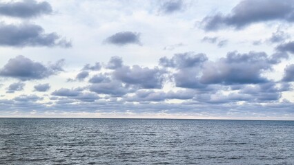 Obraz premium gentle sea waves and a blue sky filled with white clouds