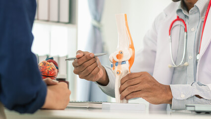 doctor is consulting and treating patient knee pain and recommending ways prevent and their health...